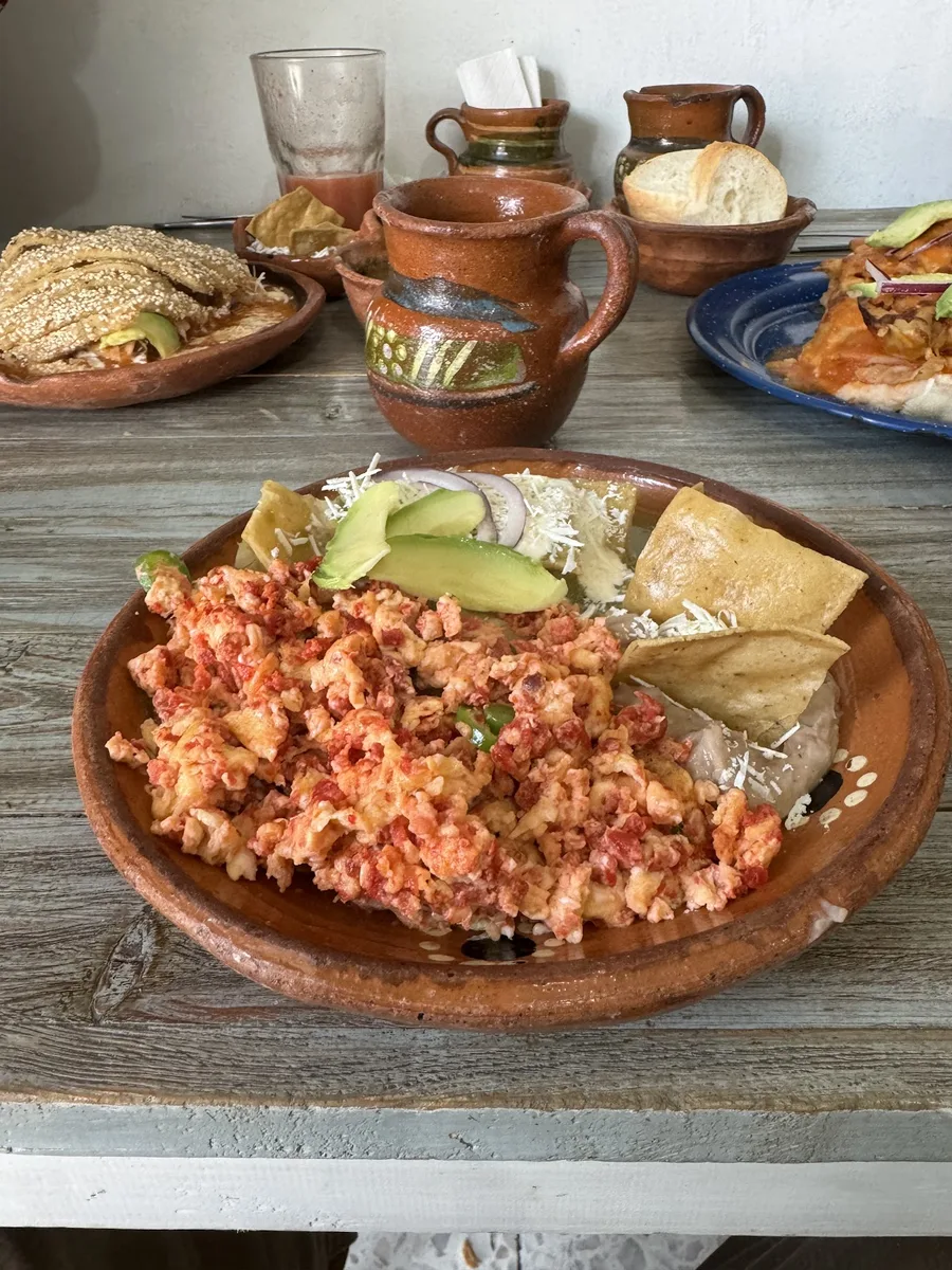 Huevos a la mexicana en cazuela de barro con aguacate, totopos y frijoles